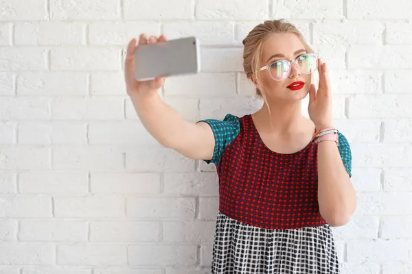 Attraktiv Ung Kvinna Tar Selfie Nära Tegelvägg — Stockfoto