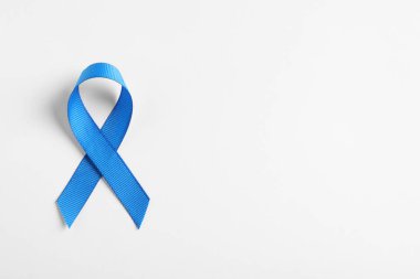 Beyaz arka plan, üstten görünüm olarak blue ribbon. Kanseri bilinçlendirme