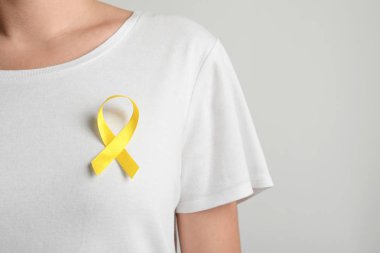 T-shirt üzerinde Sarı kurdele açık renkli karşı olan kadın. Kanseri bilinçlendirme
