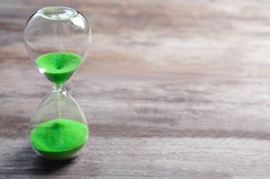 Masanın üzerinde kum akan kum saati. Zaman yönetimi