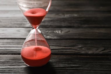 Masanın üzerinde kum akan kum saati. Zaman yönetimi