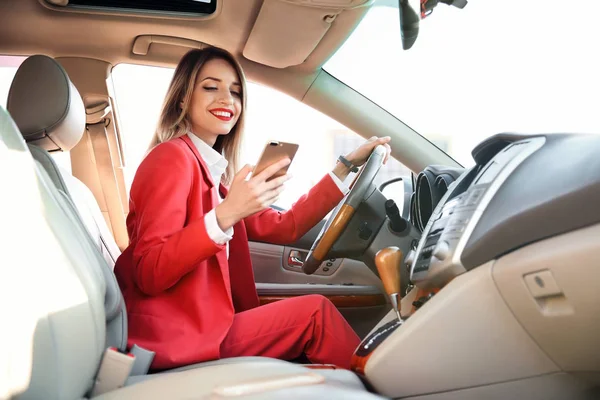 汽车司机座椅上的年轻女商人与智能手机 — 图库照片