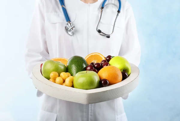 Γυναίκα Γιατρό Πλατώ Φρέσκα Φρούτα Ανοιχτόχρωμο Φόντο Καρδιακή Διατροφή — Φωτογραφία Αρχείου