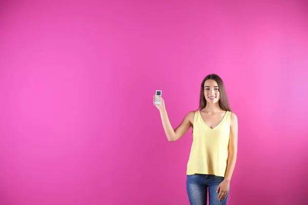 Mujer Joven Encendiendo Aire Acondicionado Fondo Color —  Fotos de Stock