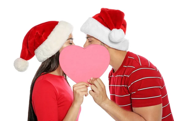 Jonge Gelukkige Paar Met Santa Hoeden Verbergen Kussen Achter Roze — Stockfoto