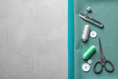 Gri arka plan üzerinde üstten görünüm aksesuarları ve kumaş dikiş seti