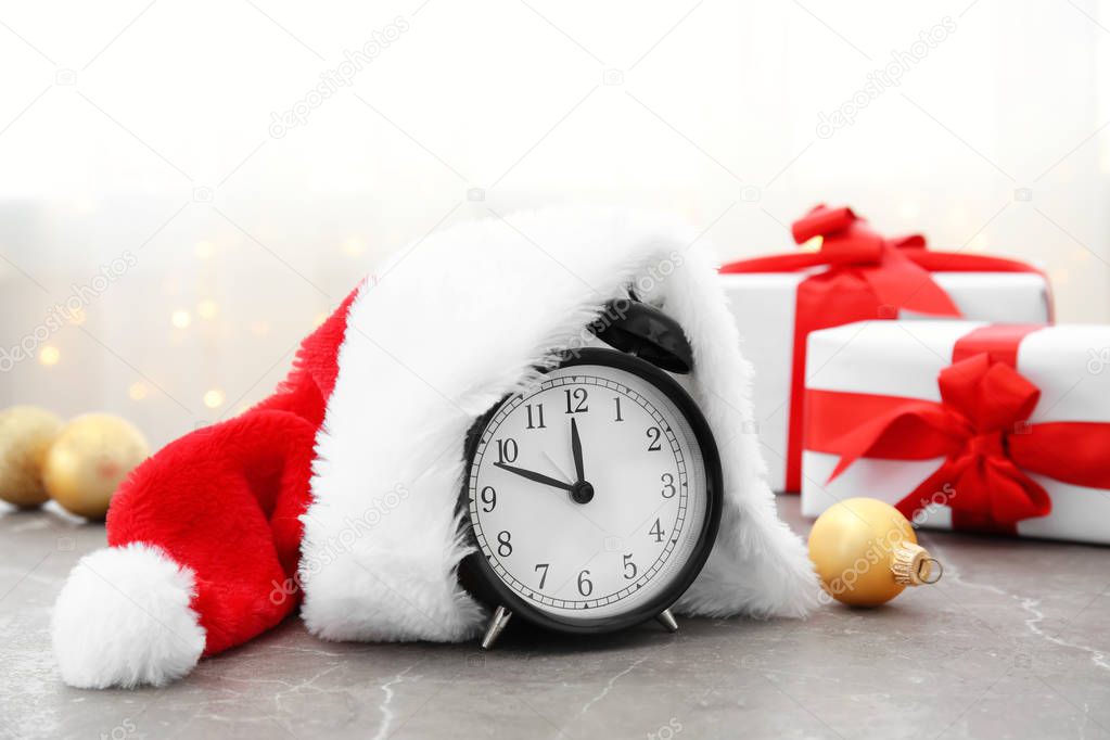 Alarm clock and Santa hat on table. Christmas countdown