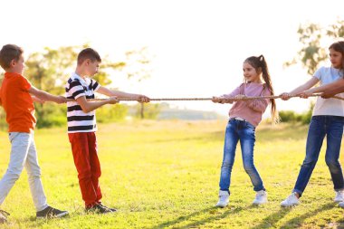 Sevimli küçük çocuklar ip ile açık havada güneşli günde oyun