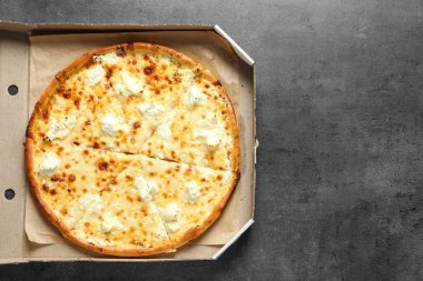 Gri zemin üzerine lezzetli pizza ile karton kutu