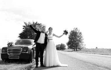 Mutlu gelin ve damat yakınındaki araba açık havada, siyah beyaz etkisi