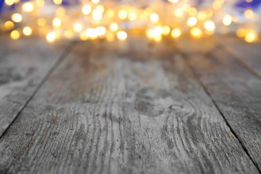 Wooden table and blurred Christmas lights on background clipart