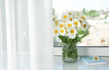 Pencere üzerinde güzel papatya çiçekli vazo