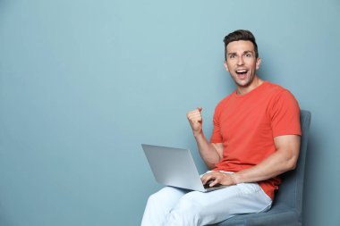 Renk arka plan üstünde laptop ile rahat kıyafetler erkekte