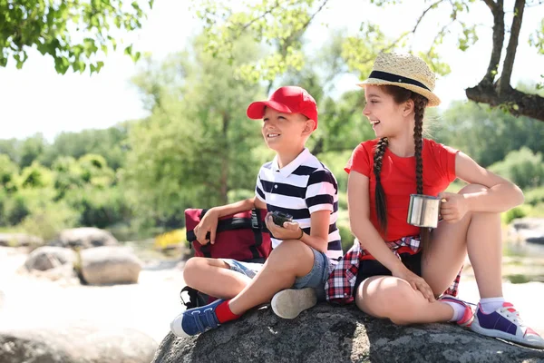 Little children with traveling gear outdoors. Summer camp