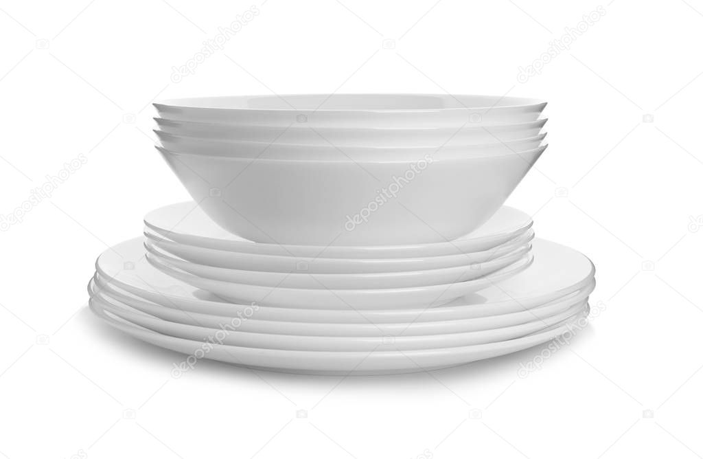 Stack of clean plates on white background