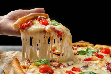 Lezzetli sıcak pizza dilim masa üzerinde closeup tutan kadın