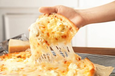 Lezzetli sıcak pizza dilim masa üzerinde closeup tutan kadın