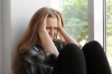 Pencere oturan depresif genç kadın