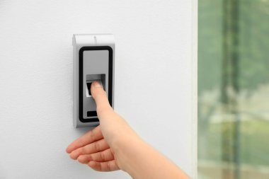 Genç kadın alarm sistemi kapalı üzerinde parmak izi tarama