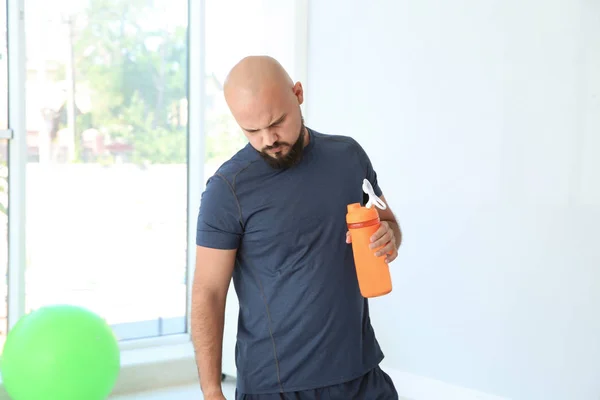 Trött Överviktig Man Med Flaska Vatten Gymmet — Stockfoto