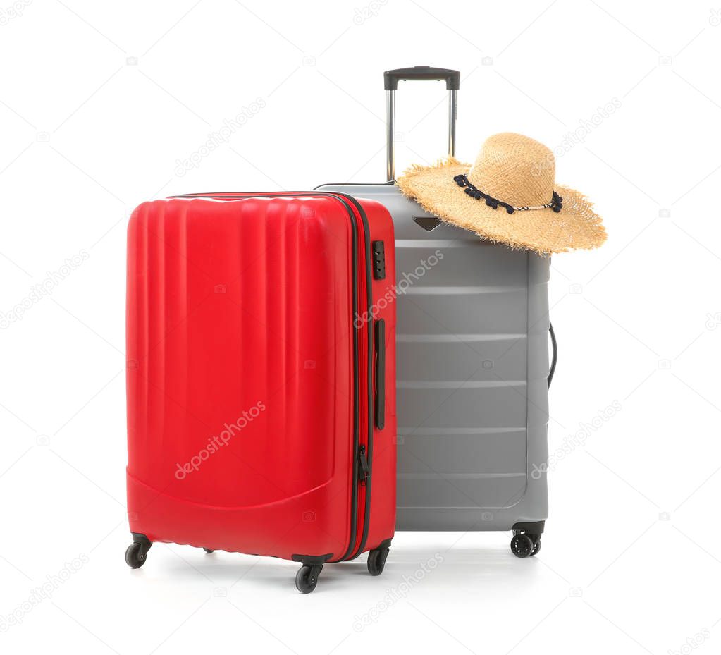 Packed suitcases with hat on white background