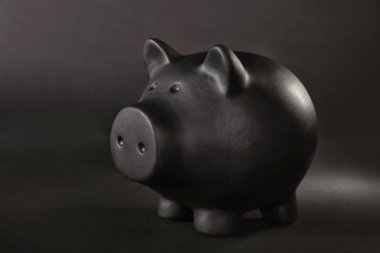 Tablo karşı koyu arka plan üzerinde siyah kumbara