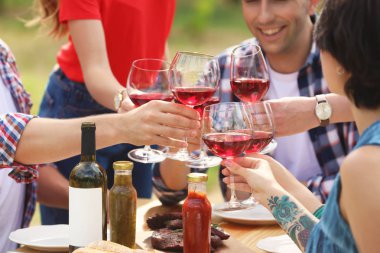 Bardak şarap masada açık havada Genç insanlarla. Yaz Barbekü