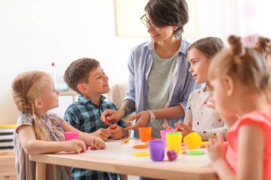 Genç kadın kapalı küçük çocuklarla oynarken