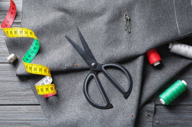 Aksesuar ve kumaş ahşap arka planda, yukarıdan dikiş seti