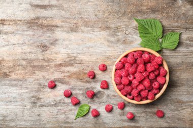 Ahşap masa, üstten görünüm üzerinde olgunlaşmış kokulu ahududu ile kase