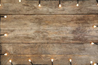 Ahşap arka plan, üstten görünüm parlak Noel ışıkları