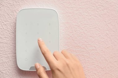 Genç kadın kapalı alarm sistemi tuş takımında kodunu girme