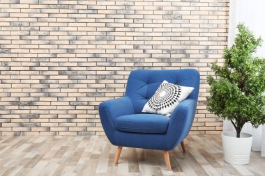Rahat koltuk minder ve houseplant duvara karşı