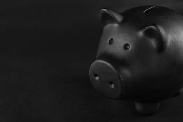 Zwarte Piggy Bank Tafel Tegen Donkere Achtergrond — Stockfoto