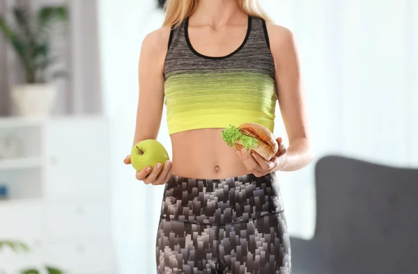 Kobieta Trzyma Smaczne Kanapki Świeże Jabłka Pomieszczeniu Wybór Pomiędzy Dietą — Zdjęcie stockowe