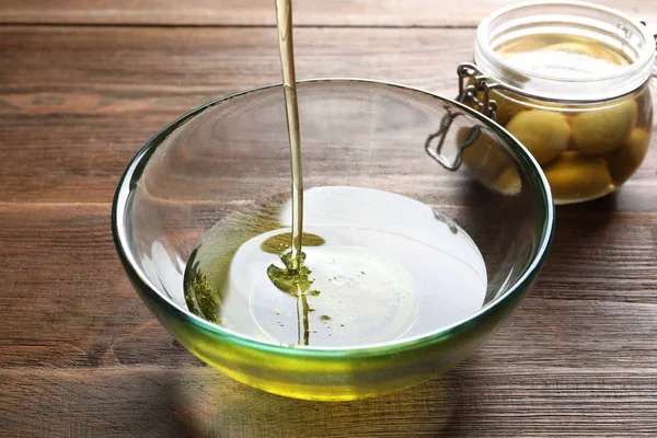 Verter Aceite Oliva Fresco Tazón Sobre Fondo Madera —  Fotos de Stock