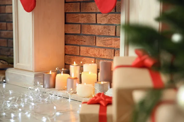 Weihnachtsbeleuchtung Neben Dekorativem Kamin Mit Kerzen Drinnen — Stockfoto