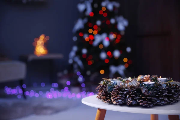 Schöner Kranz Mit Tannenzapfen Auf Tisch Und Weihnachtsbaum Dunklen Raum — Stockfoto