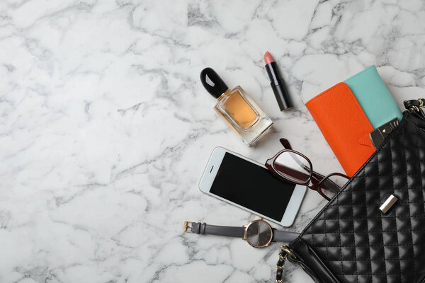 Flat lay composition with stylish bag, wallet and accessories on marble background