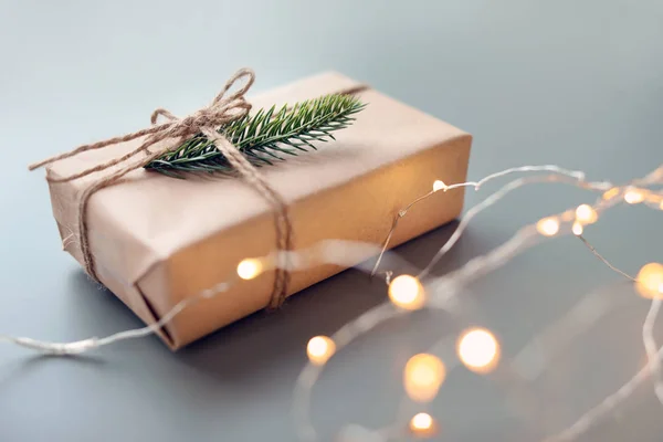 Beautiful Christmas gift box and electric garland on table