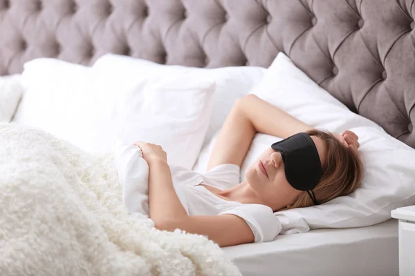 自宅のベッドで眠っているマスクと若い美しい女性 — ストック写真