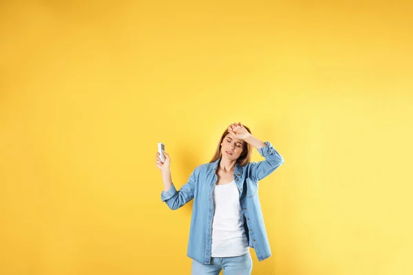 Frau Mit Klimaanlage Fernbedienung Leidet Unter Hitze Auf Farbigem Hintergrund — Stockfoto