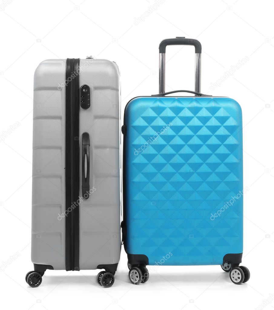 New suitcases packed for journey on white background