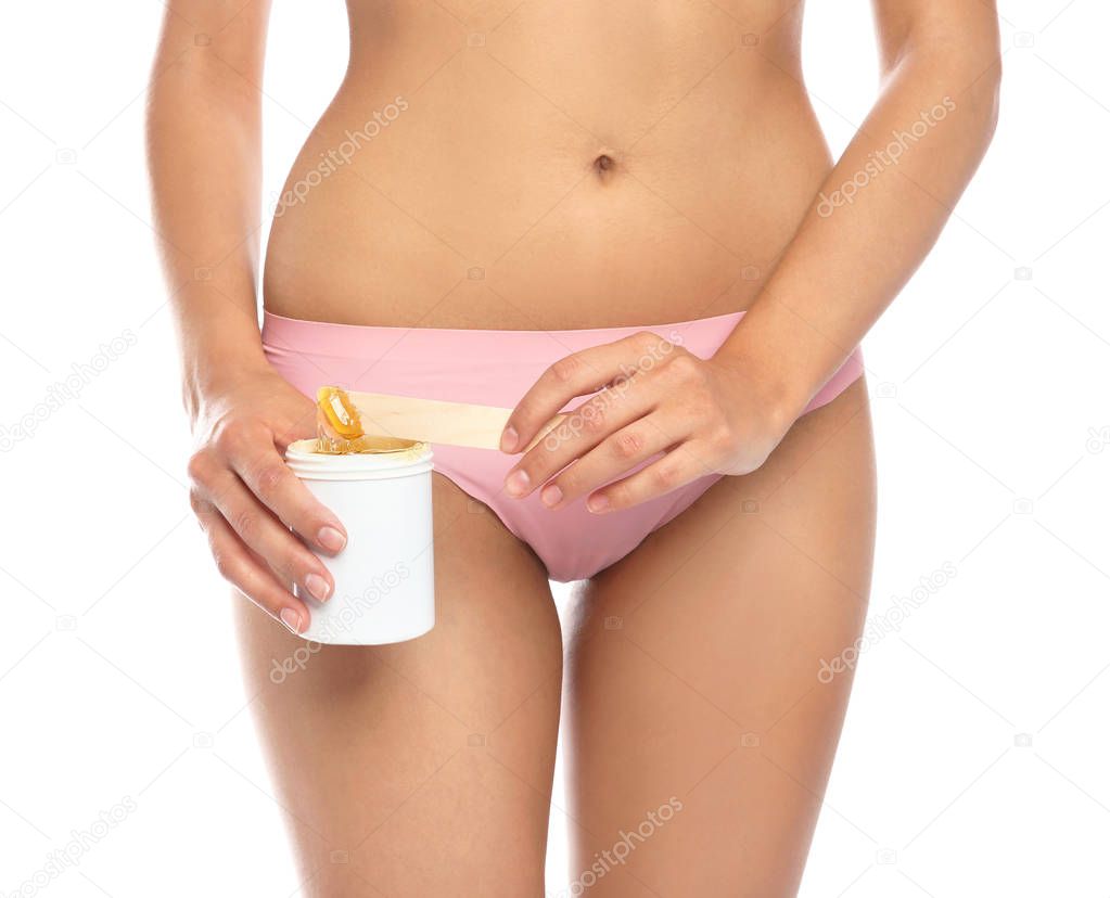 Young woman waxing bikini area on white background