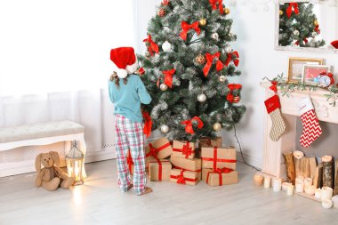 Sevimli küçük çocuk Noel ağacı evde yakınındaki Santa şapkalı