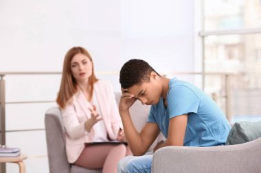 Ofiste genç çocuk ile çalışan genç kadın psikolog