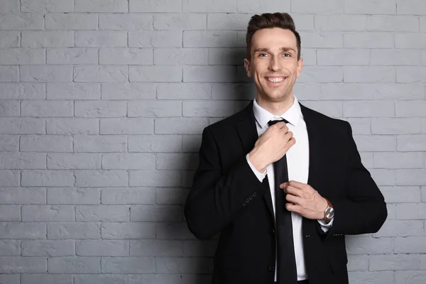 stock image Male real estate agent on brick wall background