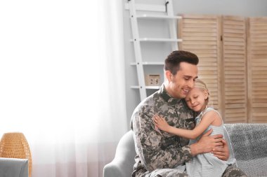 Küçük kızı evde kanepe ile askeri üniformalı genç adam