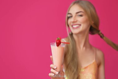 Renk arka plan üzerinde lezzetli milkshake bardak olan kadın