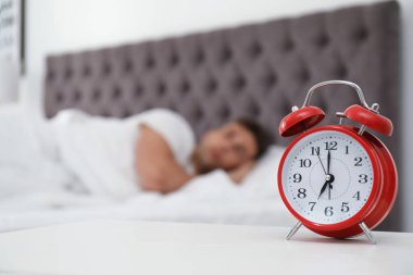 Analog alarm saat ve arka plan üzerinde bulanık adam. Günün saati